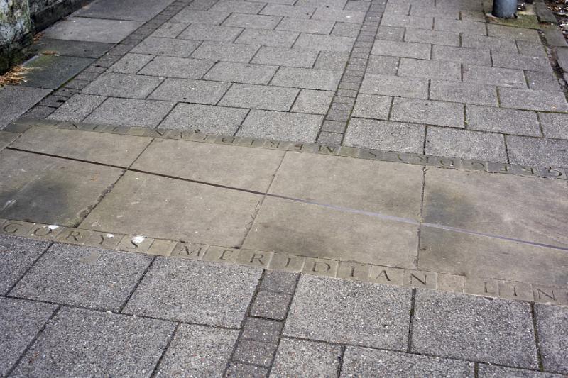 First person high angle view on carved line and letters in sidewalk at the famous Gregorys Meridian in Scotland